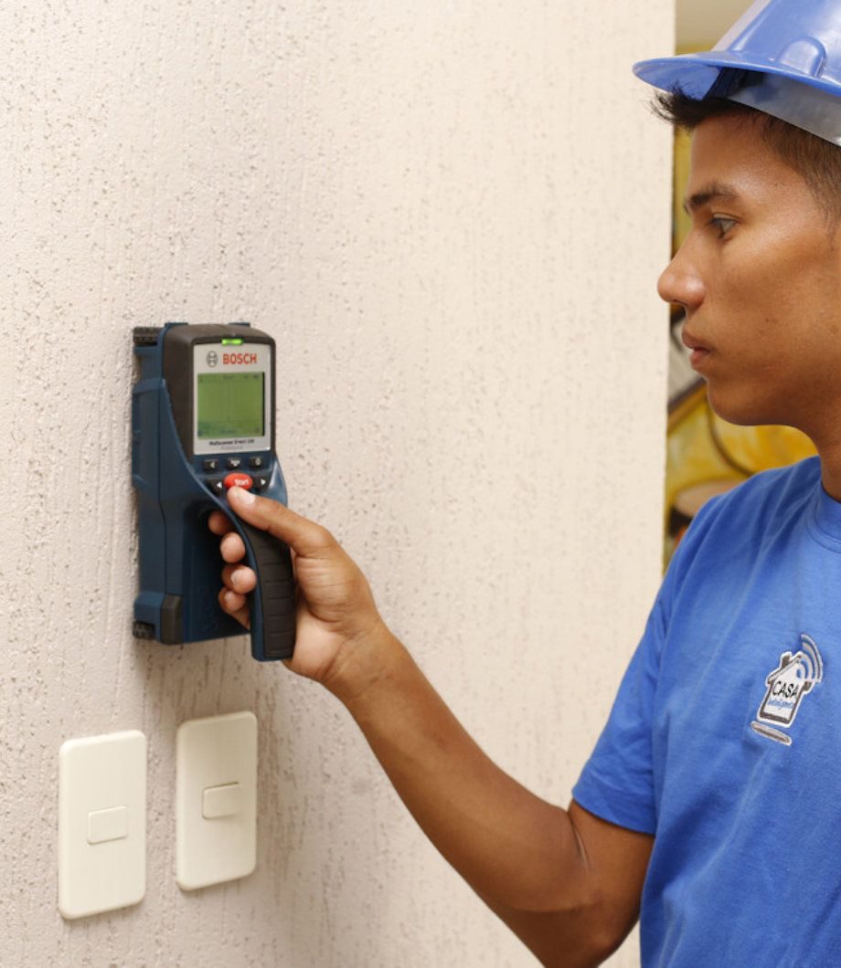 Técnico detectando cableado dentro de la pared